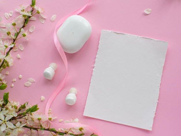 Casque sans fil sur fond rose avec fleurs de cerisier et espace de copie