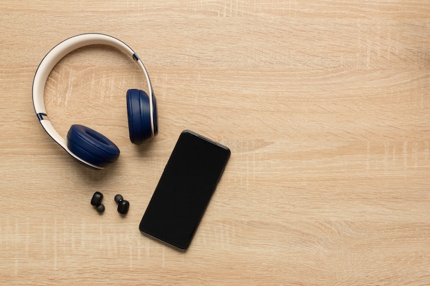 un casque sans fil et un smartphone sur une table en bois