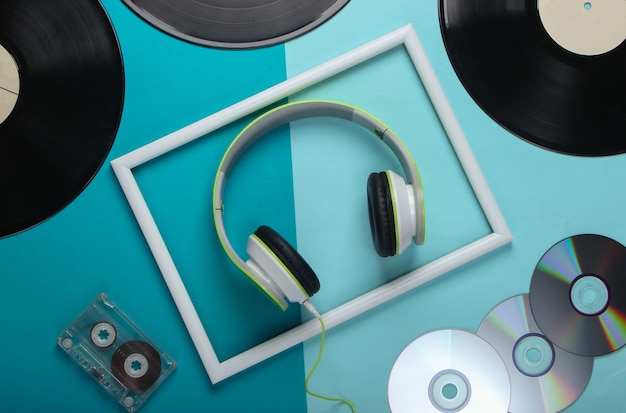 Casque Stéréo élégant Dans Un Cadre Blanc, Disques Vinyle, Cassette Audio Et Disques Cd Sur Une Surface Bleue