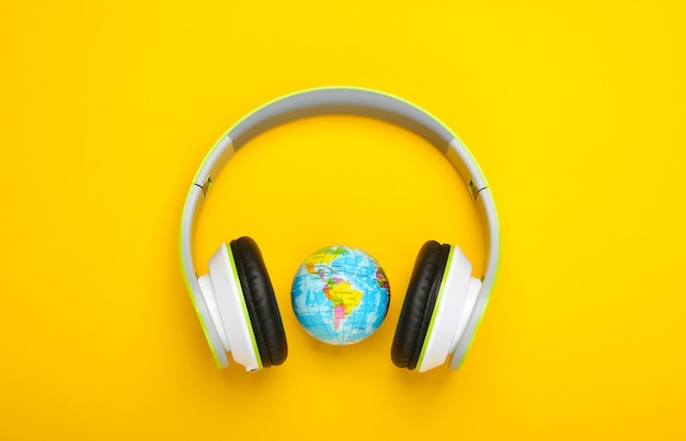 Casque stéréo et globe sur surface jaune