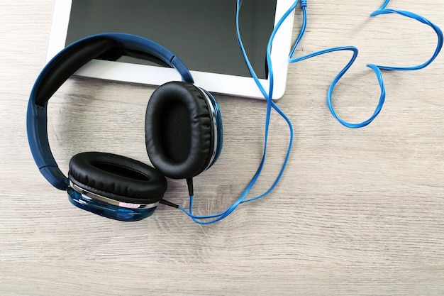 Casque avec tablette sur table en bois se bouchent