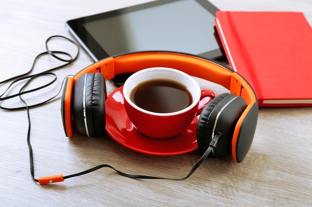 Casque avec tablette et tasse de café sur une table en bois se bouchent