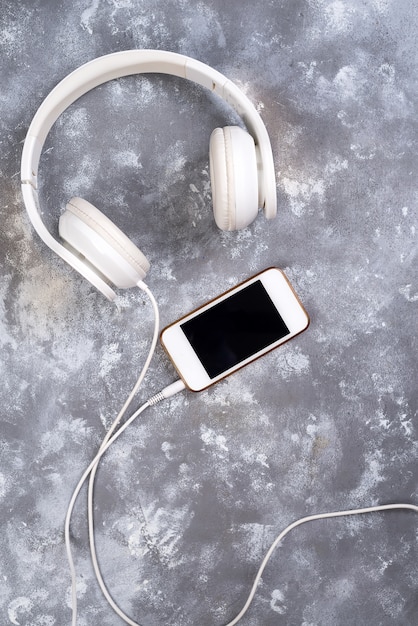 Casque et un téléphone sur un fond de pierre. Prêt à écouter de la musique.