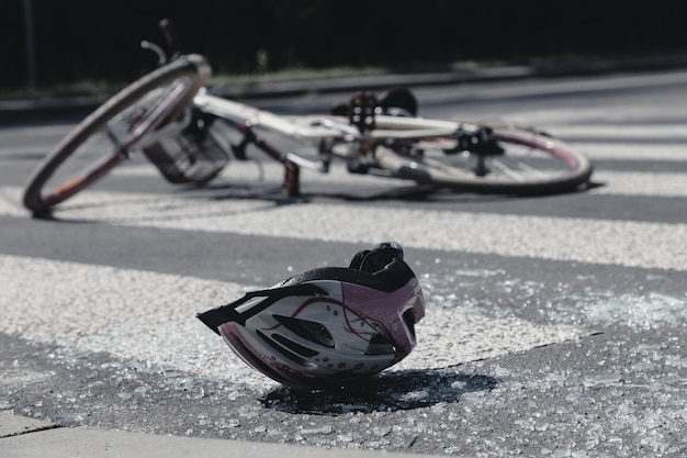 Casque et vélo d'enfant cassé sur un passage pour piétons après un terrible accident