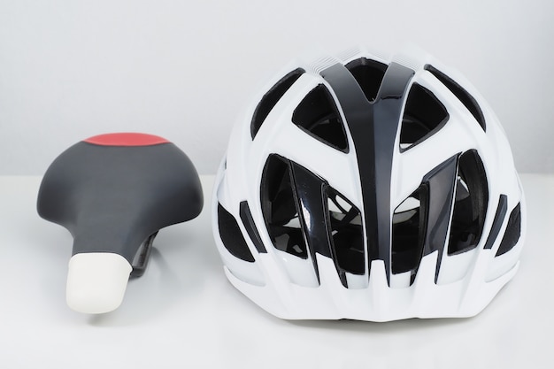 Casque de vélo et selle de sport sur fond blanc