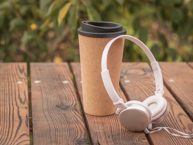 Casque et verre de café sur la table dans le parc. Passer du temps dans le café d'automne.