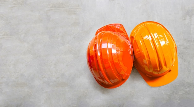 Casques de construction sur fond de béton.