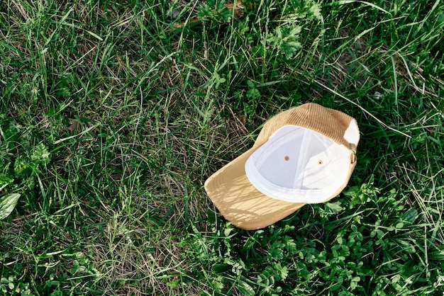 Une casquette de sport jaune se trouve à l'envers sur l'herbe verte Jeux de sports de plein air de printemps