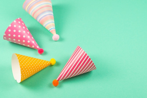 Des casquettes d'anniversaire colorées sur fond de menthe