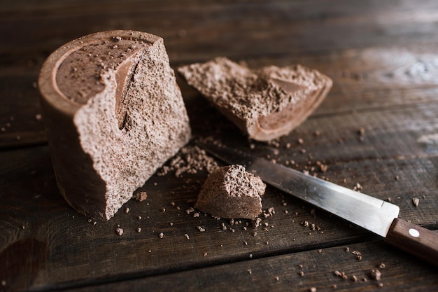 Cassé un gros morceau de chocolat aéré sur une table en bois Processus de fabrication de délicieux desserts dans l'art culinaire du restaurant photo en gros plan