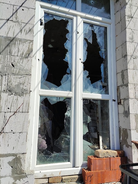 Cassé à la suite d'un bombardement d'artillerie sur une fenêtre avec du verre brisé et des murs transpercés par des balles
