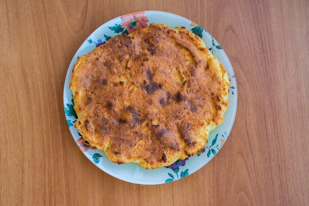 Casserole sur une assiette sur la table en bois. Fait maison