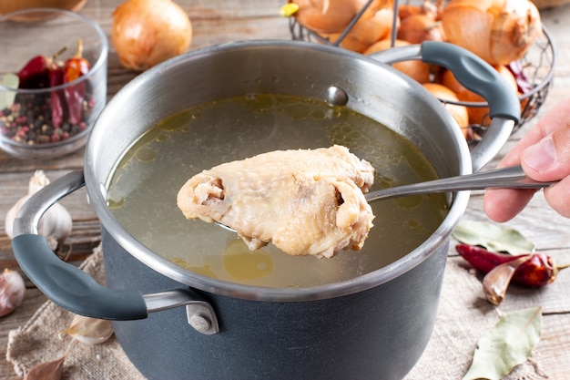 Casserole avec bouillon de poulet ou bouillon d'os sur la table en bois, régime paléo