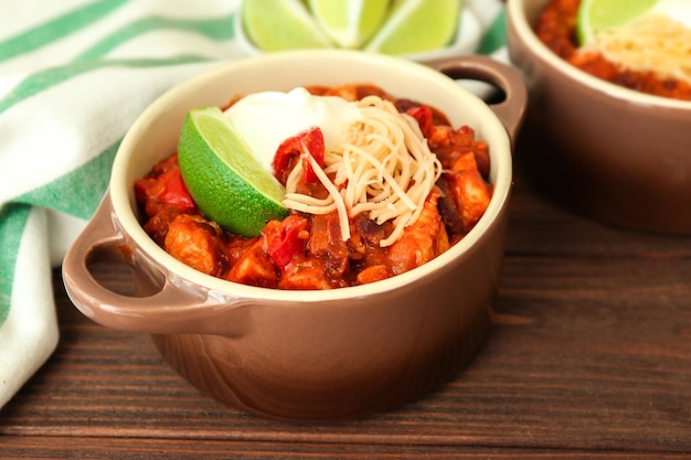 Casserole avec une délicieuse dinde au piment sur une table en bois