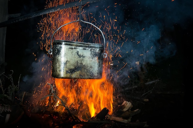 Une casserole d'eau bouillante sur le feu dans la forêt