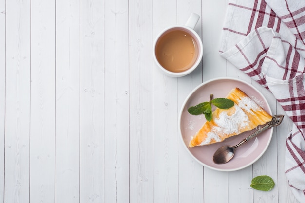 Casserole de fromage cottage sur une assiette avec du sucre en poudre et des feuilles de menthe.