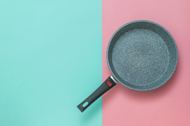 Casserole en métal avec poignée sur fond rouge et bleu