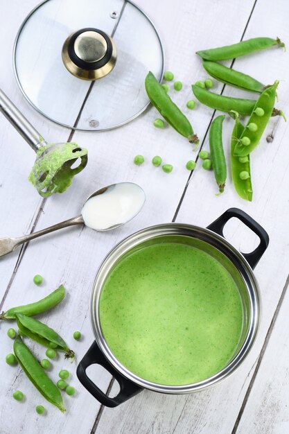 Casserole de soupe fraîchement cuite de purée de pois verts et crème sur la table