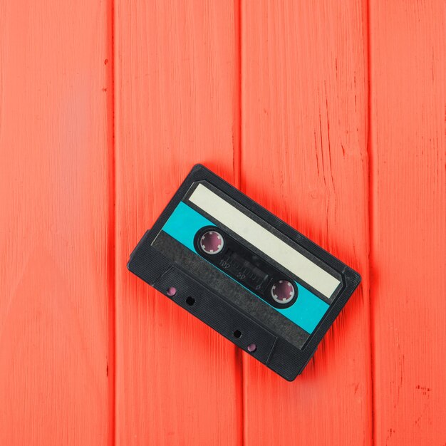 Une cassette audio sur fond de bois rouge