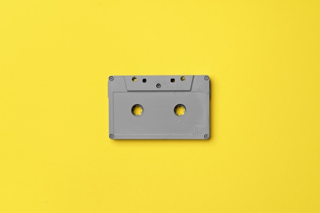 Cassette audio gris sur fond jaune vue de dessus, espace copie