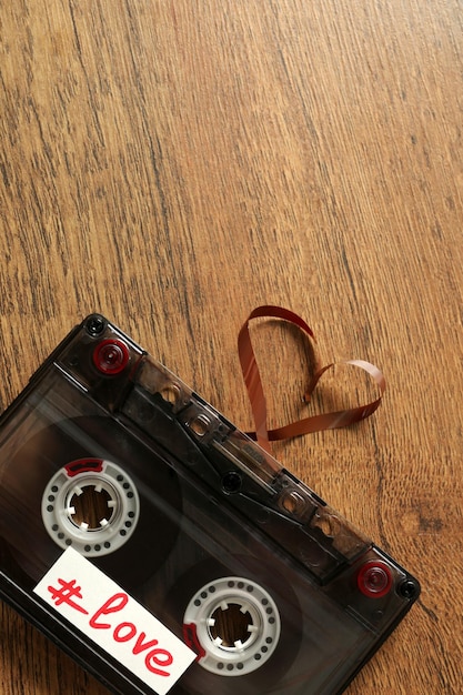 Cassette audio rétro avec bande en forme de coeur sur fond de bois