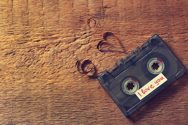 Cassette audio rétro avec bande en forme de coeur sur fond de bois