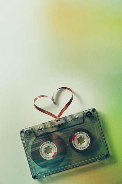 Cassette audio rétro avec bande en forme de coeur sur fond flou vert