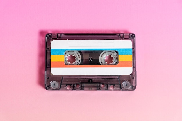 Cassette audio transparente avec étiquettes sur fond fuchsia