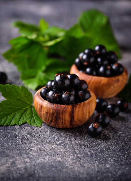 Cassis aux feuilles dans des bols en bois