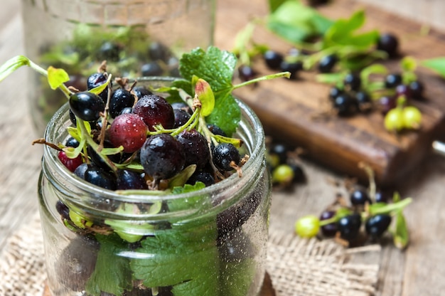 Cassis sur table en bois avec brin de feuille