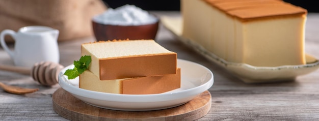 Castella Délicieux gâteau éponge japonais en tranches sur une plaque blanche sur une table en bois rustique close up saine alimentation copie espace design