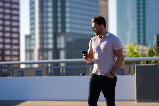 Casual bel homme bavardant au téléphone dans la ville urbaine homme bien habillé parlant au téléphone affaires en plein air