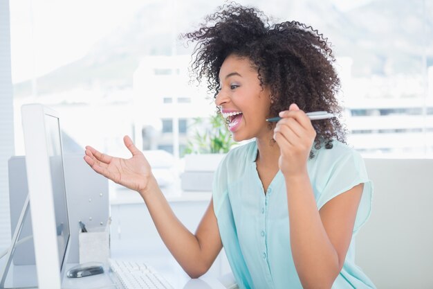 Casual femme d&#39;affaires en riant à son bureau