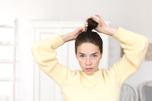 Casual femme faisant une coiffure en regardant la caméra