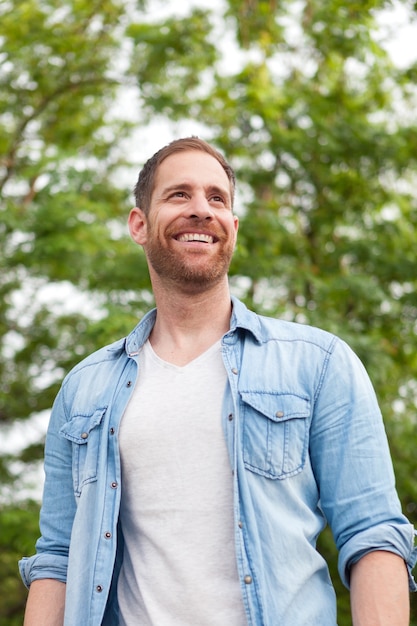 Casual guy avec une chemise en jean dans un parc