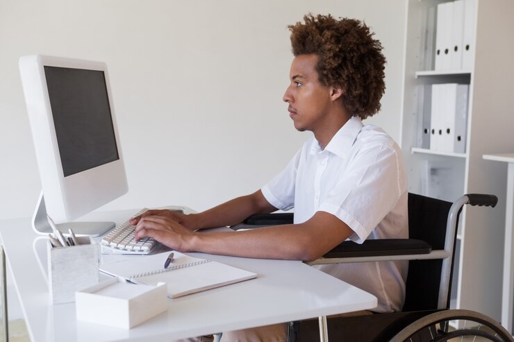 Photo casual homme d&#39;affaires ciblé en fauteuil roulant travaillant à son bureau dans son bureau