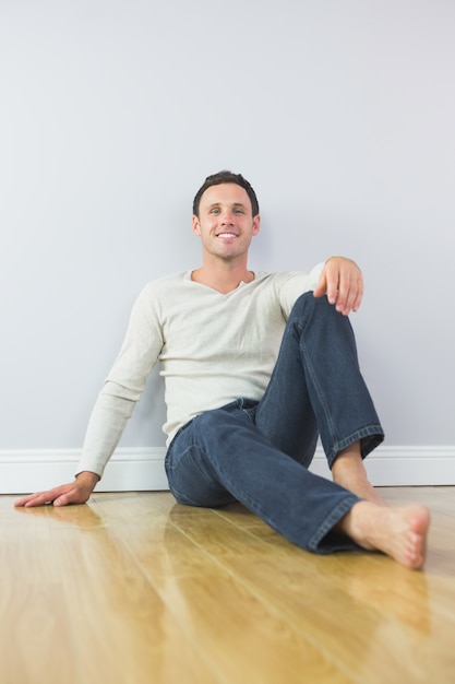 Casual homme souriant, appuyé contre le mur en regardant la caméra