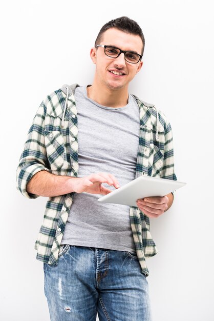 Casual jeune homme tient une tablette tactile.