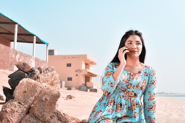 Casual jolie fille avant pose parler celphone à la plage modèle pakistanais indien