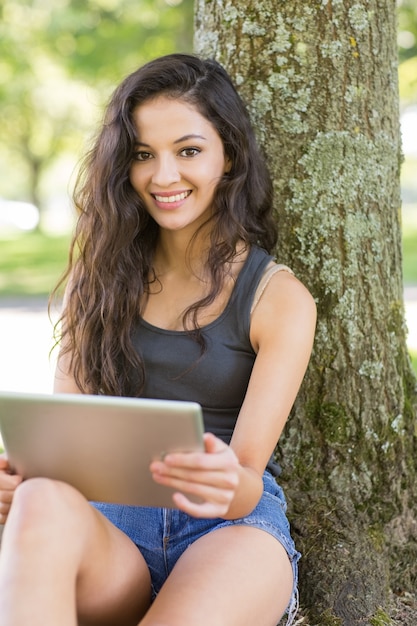 Casual séduisante brune assise avec tablette