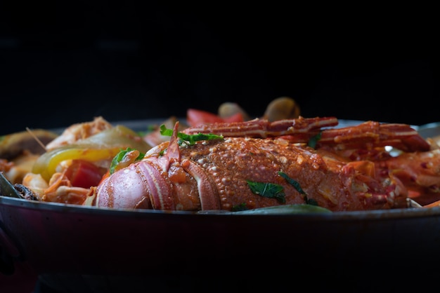 Cataplana de fruits de mer, plat typiquement portugais, avec homard, crevettes, moules, légumes.