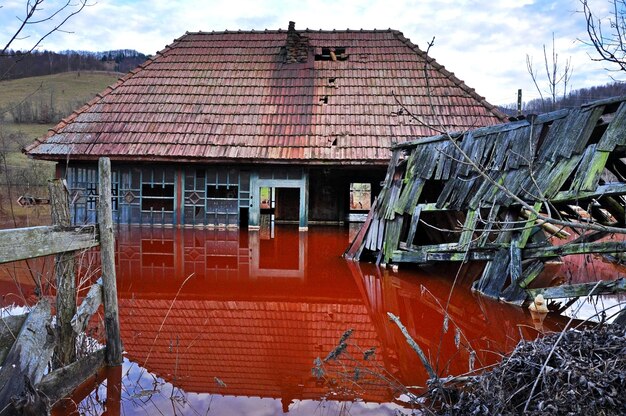 Photo catastrophe écologique un village abandonné inondé par l'eau polluée d'une mine