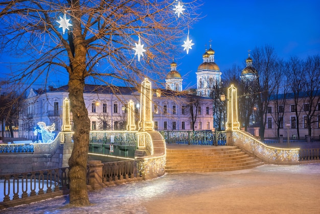 Cathédrale navale Nikolsky et étoiles festives sur un arbre à Saint-Pétersbourg et pont Krasnogvardeisky sous le ciel bleu de la nuit