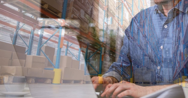 Caucasian man using laptop shopping en ligne sur un entrepôt plein de boîtes