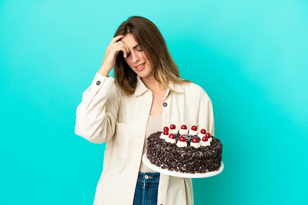 Caucasian woman holding birthday cake isolé sur fond bleu en riant