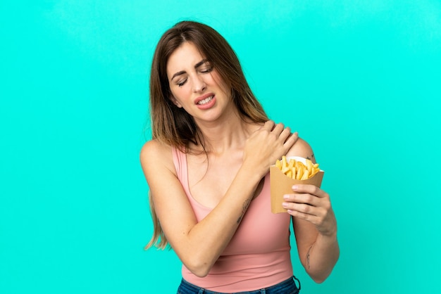 Caucasian woman holding fried chips isolé sur fond bleu souffrant de douleurs à l'épaule pour avoir fait un effort