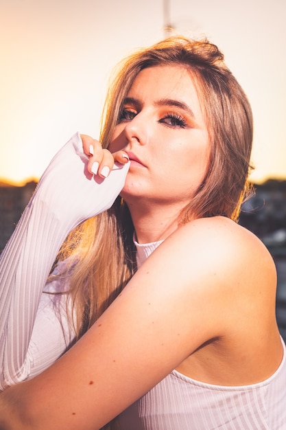 Caucasian young girl posing pendant le coucher du soleil dans un toit avec une belle vue sur Donostia-San Sebastian, Pays Basque.