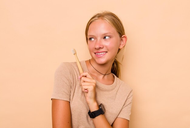 Caucasien adolescente se brosser les dents isolé sur fond beige