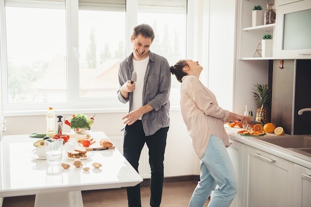 Caucasien, couple, cuisine, dans, cuisine, ensemble, et, sourire, jouer, et, trancher, fruits