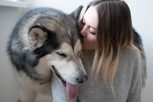 Caucasien femme baiser chien Malamute d'Alaska.